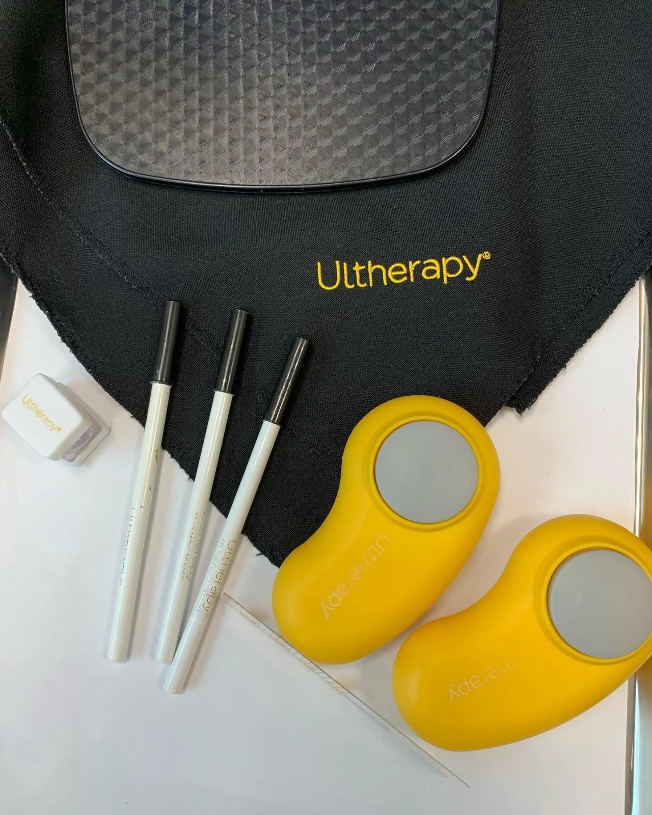 Ultherapy skin tightening device components including black treatment pad, three applicator wands, and yellow handheld devices